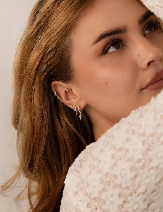 Model mit mehreren getragenen Weißgold Ohrringen.
